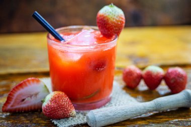 Ahşap arka planda taze çilek içeceği, Brezilya ÇilekCaipirinha barda yer. Metin için boşluk. Menü için fotoğraf.