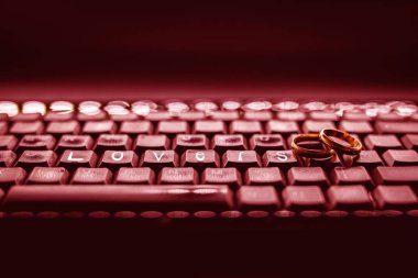 Sadakatsizlik ya da sanal ihanet kavramı. Kişisel bilgisayar klavyesi üzerinde Altın alyans, kelime severler vurgulanır.