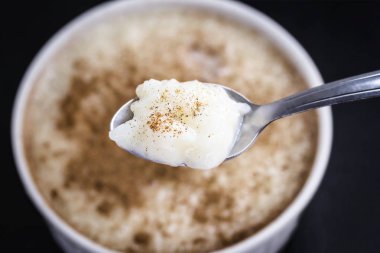 Sütlaç ve tarçın ile Kaşık. Brezilya'dan tipik tatlı, lezzetli bir yulaf lapası.