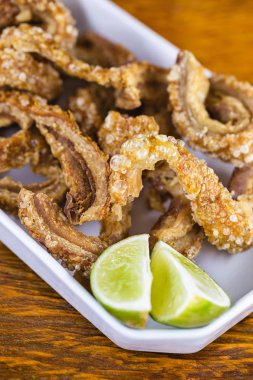 domuz derisi (torresmo) restoranda rustik ahşap masada seramik kase kızarmış. Brezilya ve Asya mutfağından tipik yemek