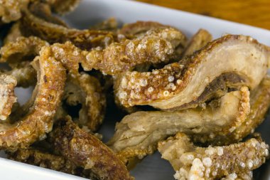 domuz derisi (torresmo) restoranda rustik ahşap masada seramik kase kızarmış. Brezilya ve Asya mutfağından tipik yemek