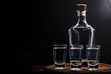 Aguardiente veya aguardente Geleneksel İspanyol ve Brezilya alkollü içecek, güçlü içecek, üzüm brendi, rom, cin, gümüş tekila, pinga, Brezilya cachaca, Rus votka, eski bir rustik ahşap masa üzerinde gözlük, metin için yer. Geleneksel içki