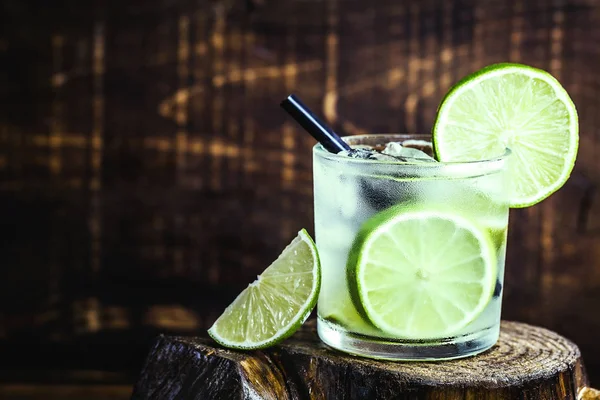 Verão fresco caipirinha alcoólica em uma mesa de madeira rústica, festa bebe fundo coquetel. Espaço para SMS. Bebida fria do verão brasileiro . — Fotografia de Stock