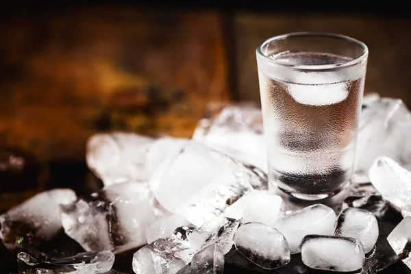 Cold cocktail with tonic, vodka and ice on wood background — Stock Photo, Image