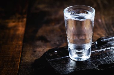 Ahşap arka planda tonik, votka ve buz içeren soğuk kokteyl. Dünya Votka veya Brendi Günü