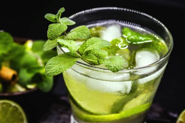 Koyu ahşap masada Mojito kokteyl. Mojito, nane yaprakları ile caipirinha gibi rom içecek.