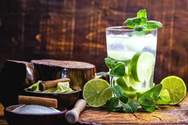 Mojito is a white rum-based cocktail made in Cuba. Tourist drink created in Havana. alcoholic drink on rustic wood background, image for menu or restaurant.