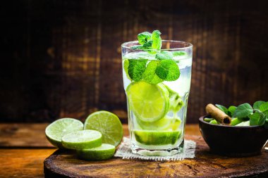 Barda Mojito kokteyli. Rustik ahşap üzerinde Mojito kokteyl. Soğuk Mojito, rom, limon ve nane turist içeceği. Menü veya restoran için resim.