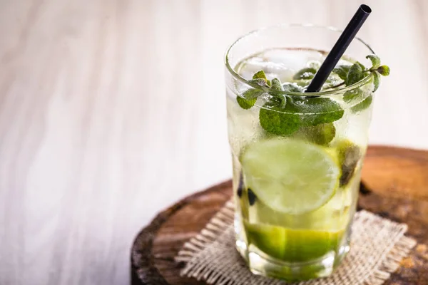 Mojito, známý kubánský nápoj na celém světě. Čerstvý Mojito ve skleničkách na dřevěném stole. — Stock fotografie