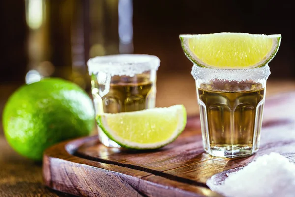 Distilled drink with salt and lemon. Glass of tequila, typical mexican drink in a bar. International Tequila Day.