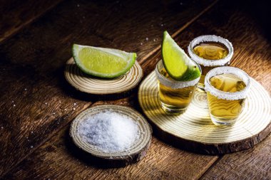 Ahşap zemin üzerinde limon ve deniz tuzu ile tekila shot, seçili odak