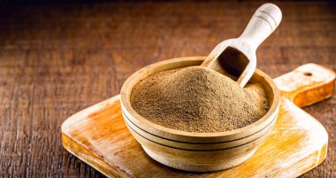 Tarçın tozu, ahşap bir tencerede toprak, ahşap bir kaşık. Organik, sağlıklı ürün..