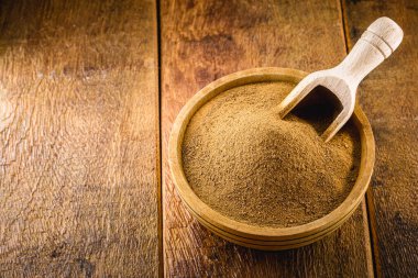 Tarçın tozu, ahşap bir tencerede toprak, ahşap bir kaşık. Organik, sağlıklı ürün..