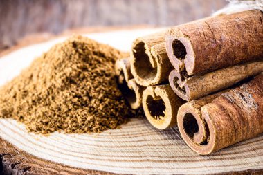 Zemin tarçın ve tarçın, leke odaklı. Mutfak baharatının makro fotoğrafçılığı.