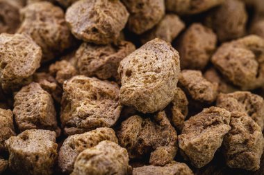 Soya fasulyesi yığını, tahtadan arka planda granüle soya proteini, vejetaryen ya da vejetaryen yemeklerde et yerine kullanılan yiyecekler..