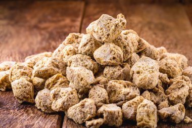 Soya fasulyesi yığını, tahtadan arka planda granüle soya proteini, vejetaryen ya da vejetaryen yemeklerde et yerine kullanılan yiyecekler..