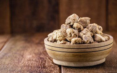 Granulated Pembe Soya Proteini. Kırsal ahşap arka planda soya bazlı protein.