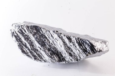 Beyaz arka planda izole edilmiş nikel metal parçasının makro çekimi. Endüstride kullanılan parlak kaba mineral krom taşının yakın plan fotoğrafı.