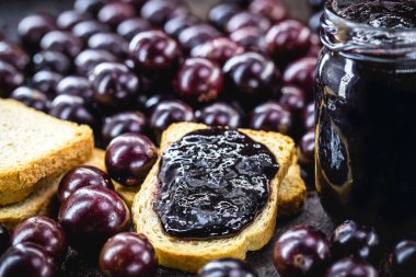 Kırsal ahşap masada üzüm reçelli tost. Jabuticaba, egzotik Brezilya meyvesi, yemek pişirmede tatlı olarak kullanılır..