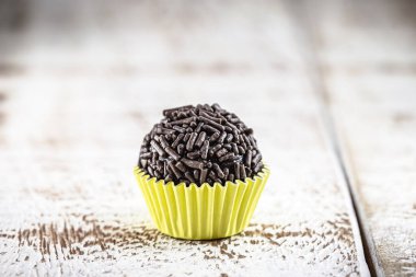 Brigadeiro (veya negrinho), çocuk partilerinde kullanılan beyaz arka plandaki ahşap masa üzerindeki Brezilya çikolatası şekeri.