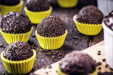 Brigadeiro ou negrinho, Brezilya 'daki çocukların doğum günü partileri için tipik bir şekerleme, kırsal masa üzerine dakik bir odak noktası.