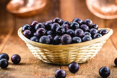 Jaboticaba ya da Jabuticaba, Brezilya ve Güney Amerika meyveleri, kırsal ahşap bir sepetin içinde. Tatlılarda, jölelerde, içeceklerde ve tıbbi kullanımlarda kullanılan meyveler.