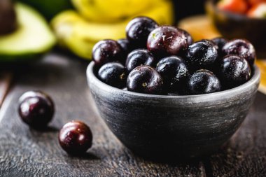 Jaboticaba ya da Jabuticaba, Brezilya ve Güney Amerika meyveleri, bir çömlek içinde. Arka planda tropik meyveler var..