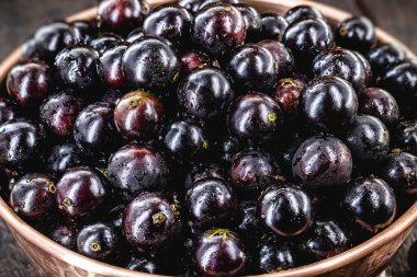 Jabuticaba. Brezilya ve Güney Amerika tropikal meyveleri, kırsal bir masada bakır bir tencerede