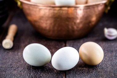 Renkli caipira yumurtası Brezilya 'nın tipik bakır kapta, kırsal ahşap arka planda