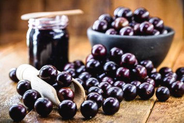 Brezilya üzümü reçeli, ahşap bir masada. Jabuticaba, Brezilya 'dan gelen egzotik meyve, yemek pişirmede tatlı olarak kullanılır..