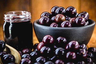 Brezilya üzümü reçeli, ahşap bir masada. Jabuticaba, Brezilya 'dan gelen egzotik meyve, yemek pişirmede tatlı olarak kullanılır..