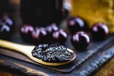 Kırsal ahşap masada üzüm reçelli tost. Jabuticaba, egzotik Brezilya meyvesi, yemek pişirmede tatlı olarak kullanılır..