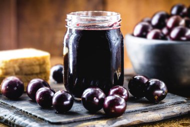 Brezilya üzümü reçeli, ahşap bir masada. Jabuticaba, Brezilya 'dan gelen egzotik meyve, yemek pişirmede tatlı olarak kullanılır..