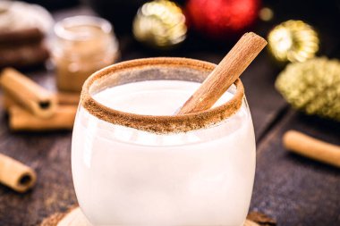 Sıcak, geleneksel Noel eggnog rendelenmiş hindistan cevizi ve tarçınlı.