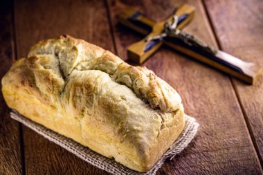 Paskalya ve Ekmek Dönemi 'nde yapılan ev yapımı ekmek, adı İsa ekmeği, dini sembol, arka planda İncil ve haç var.