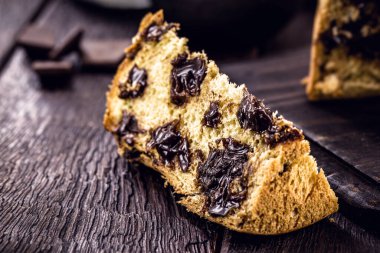 Büyük bir dilim çikolatalı panettone, tipik Brezilya tatlısı, kırsal ahşap bir masada. Noel şekeri