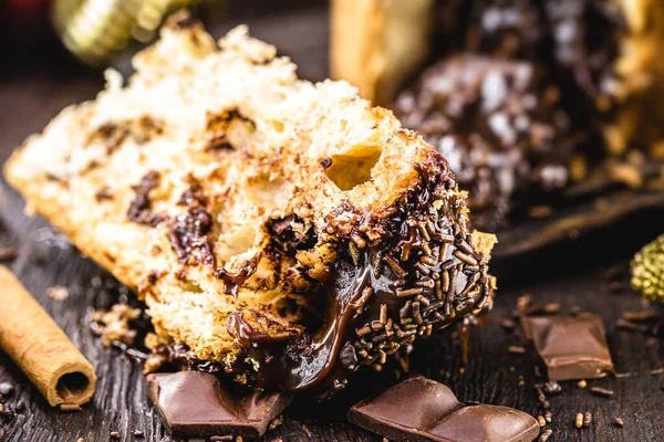 Büyük bir dilim çikolatalı panettone, tipik Brezilya tatlısı, kırsal ahşap bir masada. Noel şekeri