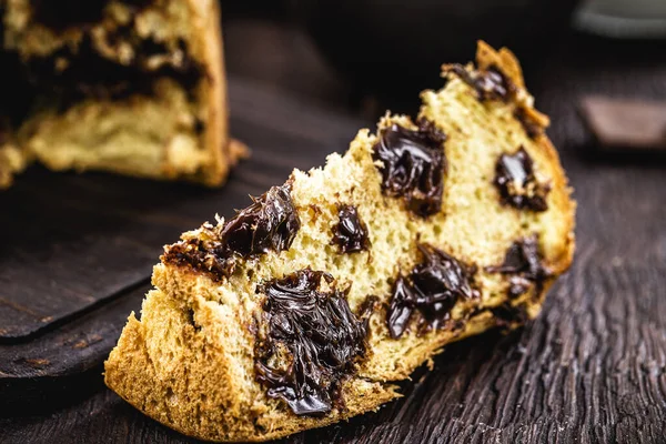 Çikolatalı panettone, sade ahşap arka planda izole edilmiş, yazı için yer var. Dünyanın çeşitli ülkelerinde tipik Noel tatlısı.