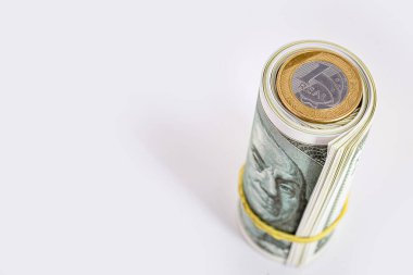 Bir paket ya da rulo Amerikan parasına gerçek bir bozuk para. Dolara karşı gerçeğin devalüasyonu kavramı, izole edilmiş beyaz arka plan