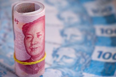 100 Yuan 'lık banknotlar, bulanık arkaplanda Brezilya' dan 100 reais banknotlar. Çin piyasa değeri ve Renminbi para birimi