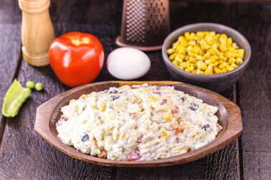 Meyve ve sebzeli Brezilya mayonezi, kırsal mutfak, arka planda ahşap kaplar.