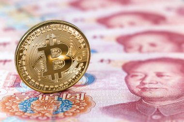 100 Yuan 'lık banknotların yanında bitcoin paraları, Çin parası, merkezi olmayan ekonomi konsepti