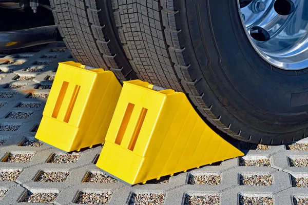停車中のトラックの車輪で黄色の輪止め — ストック写真