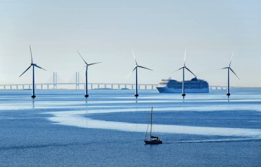 Çok büyük yolcu gemisi ve küçük bir yelkenli deniz rüzgar türbinleri Öresund Köprüsü yakınlarında Danimarka ve İsveç arasındaki geçiş