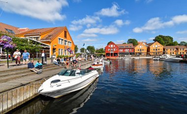 Kristiansand, Norway - July 19, 2017: Motorboats navigate on a canal in the Fiskebrygga district in Kristiansand, Norway. clipart
