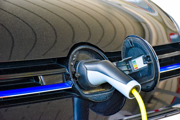 Bir elektrikli araç şarj istasyonu ücret uygulanır. Şarj fişi marka logosu gizli yuvaya takıldığından.