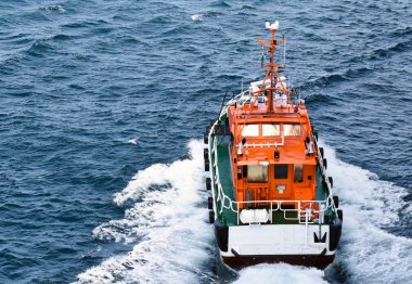 Bir turuncu pilot tekne yüksek hızda yelken