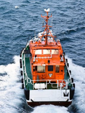 Bir turuncu pilot tekne yüksek hızda yelken