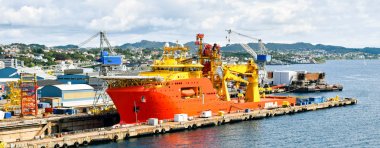 Bir büyük portakal ve sarı renkli Offshore inşaat gemi (Ocv) bir kuru havuzda bir tersane ve tamir ediliyor