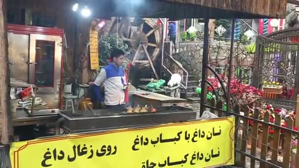 ТЕХН, ИИН, АПРЕЛЬ 2019: уличная еда в Дарбанде, иранский город Тегеран. Ресторан у реки — стоковое видео